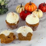 Pumpkin cupcakes with cream cheese filling on the table.