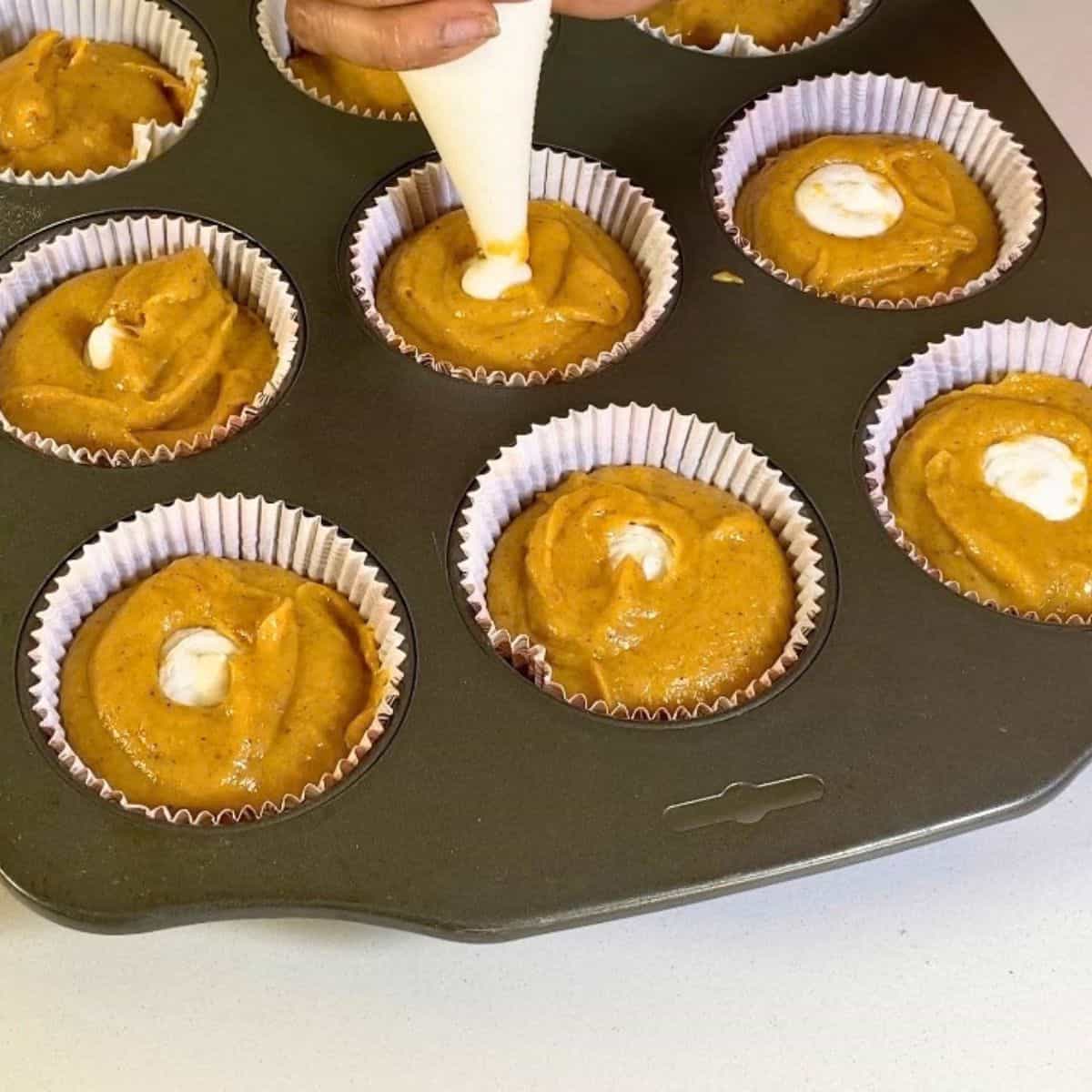 Cream cheese filling in pumpkin cupcakes.