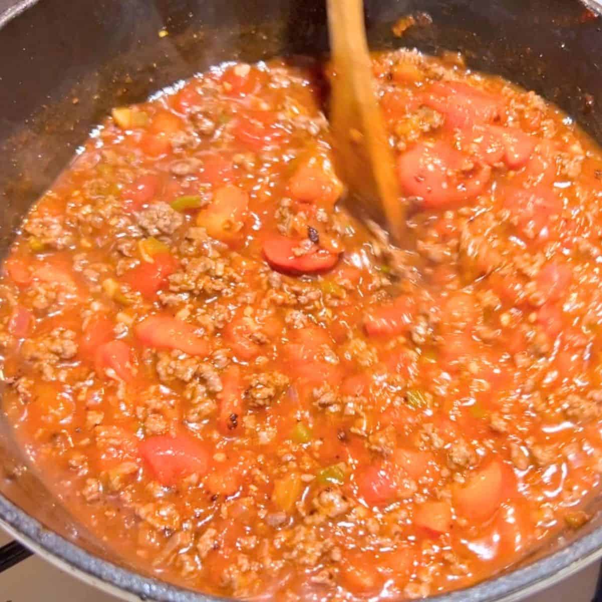 A cast iron skillet with ground beef and beans.