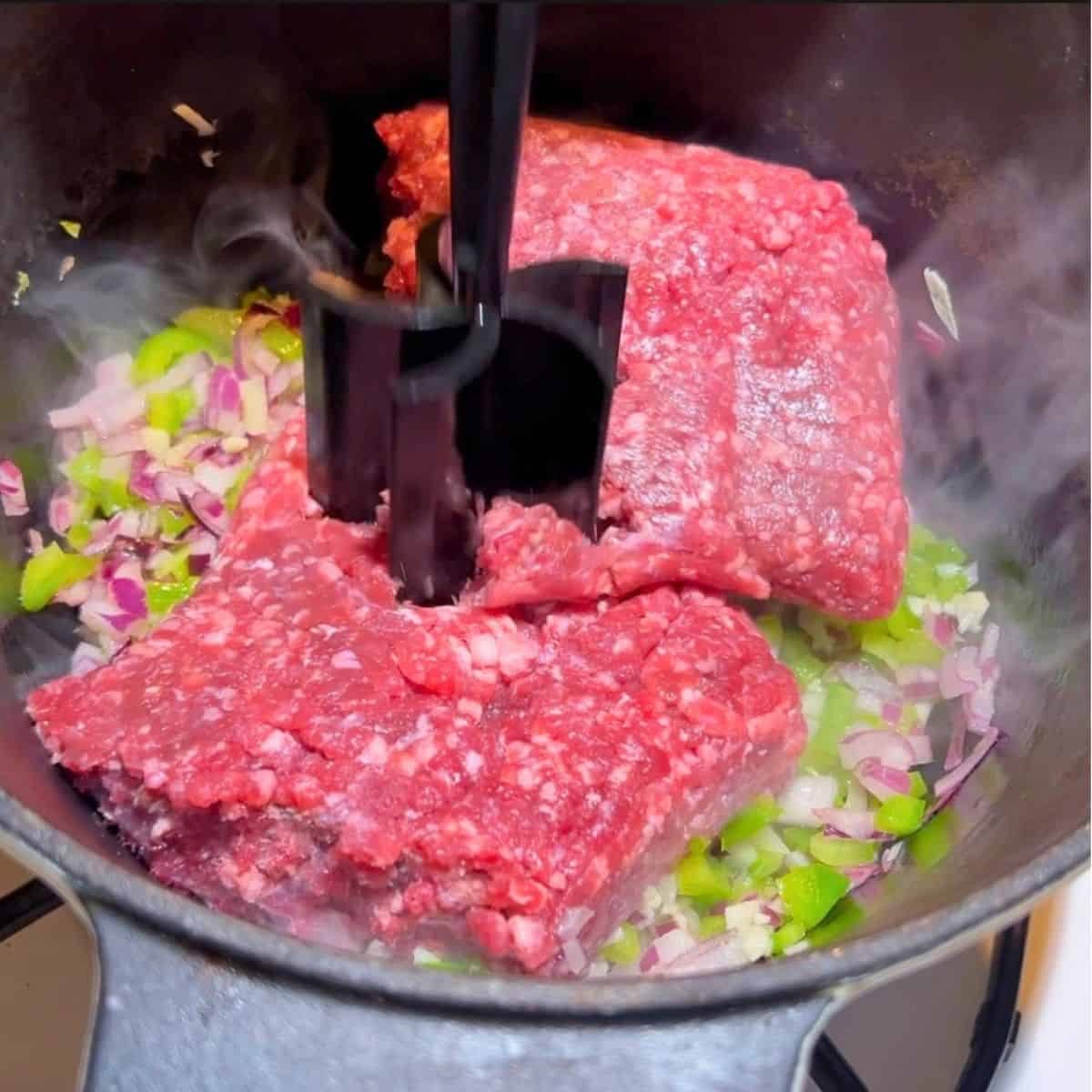 Browning the ground beef in a cast iron skillet.