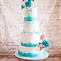 A wedding cake decorated with turquoise lace theme.